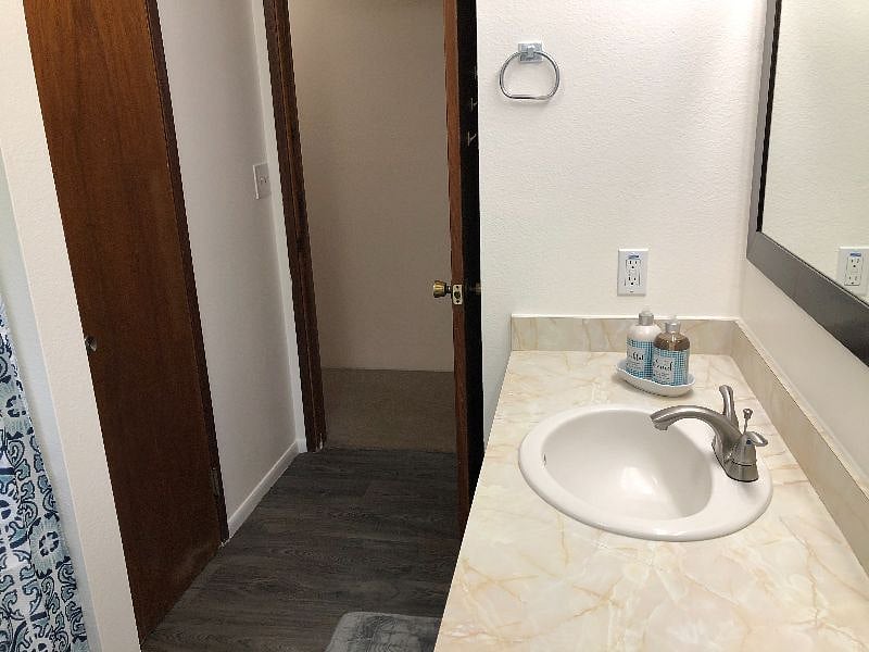 Main bathroom with new sink faucets, paint and vinyl flooring
