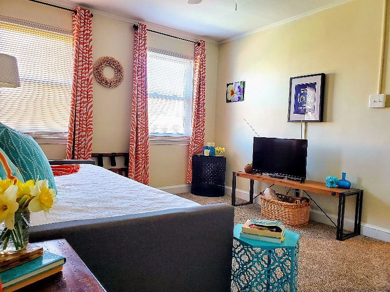 Seperate living room has TV and plenty of natural light and storage.