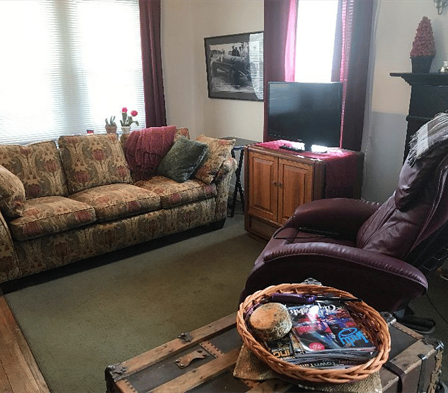 The living room has a sofa, a massage chair, and a SMART TV.