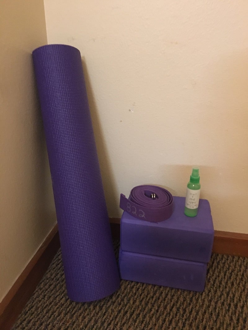 Yoga nook with props and cleaner.