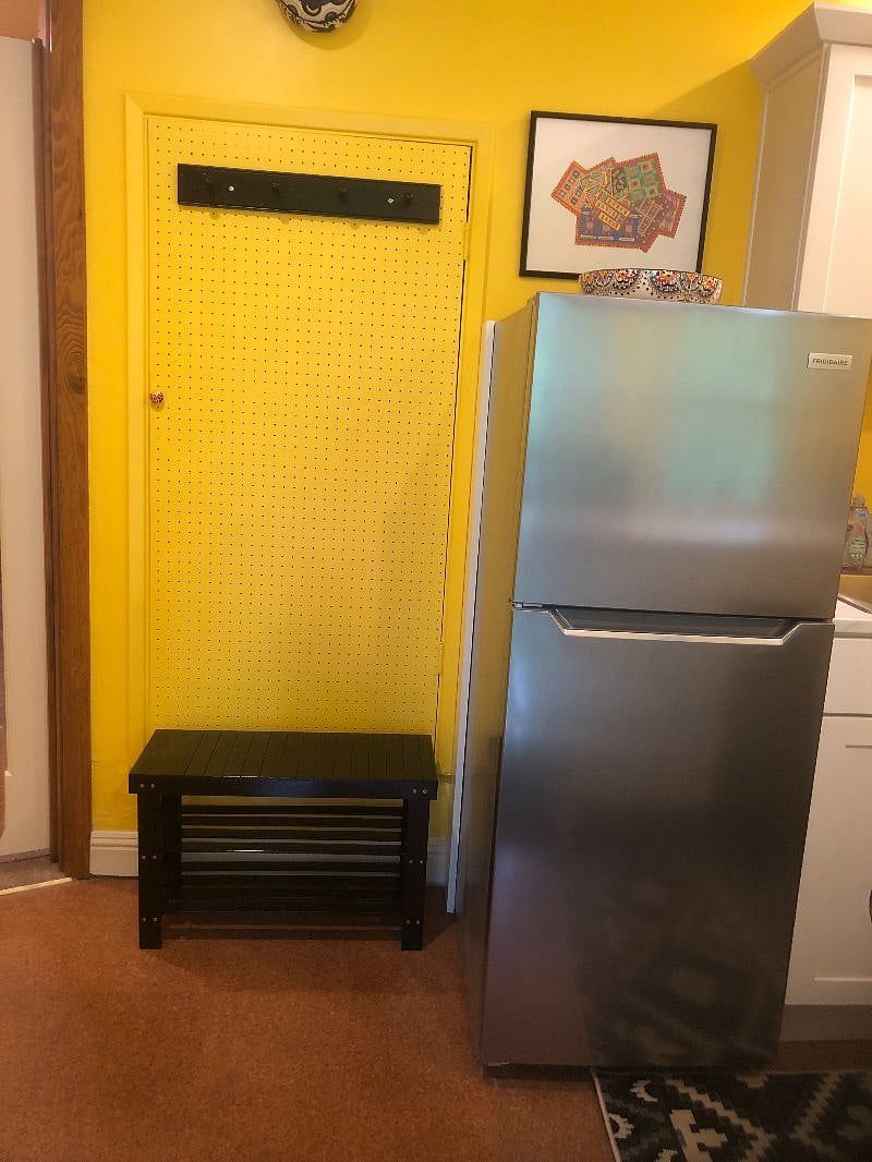 Entrance with shoe bench and coat pegs above.