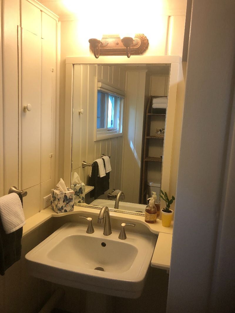 Pull-down sink faucet. Towels, shampoo, hairdryer. Privacy window shade. More storage in medicine cabinet next to sink and three shelves over toilet.