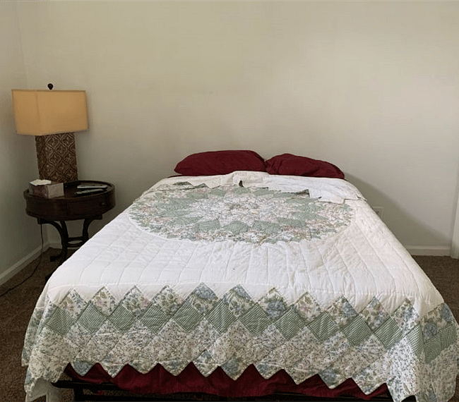 A nightstand with a lamp on to make your room cozier.