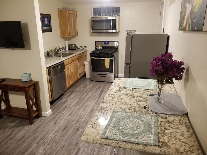 Full kitchen with hickory cabinets , stainless steel fridge, dishwasher and gas range/oven