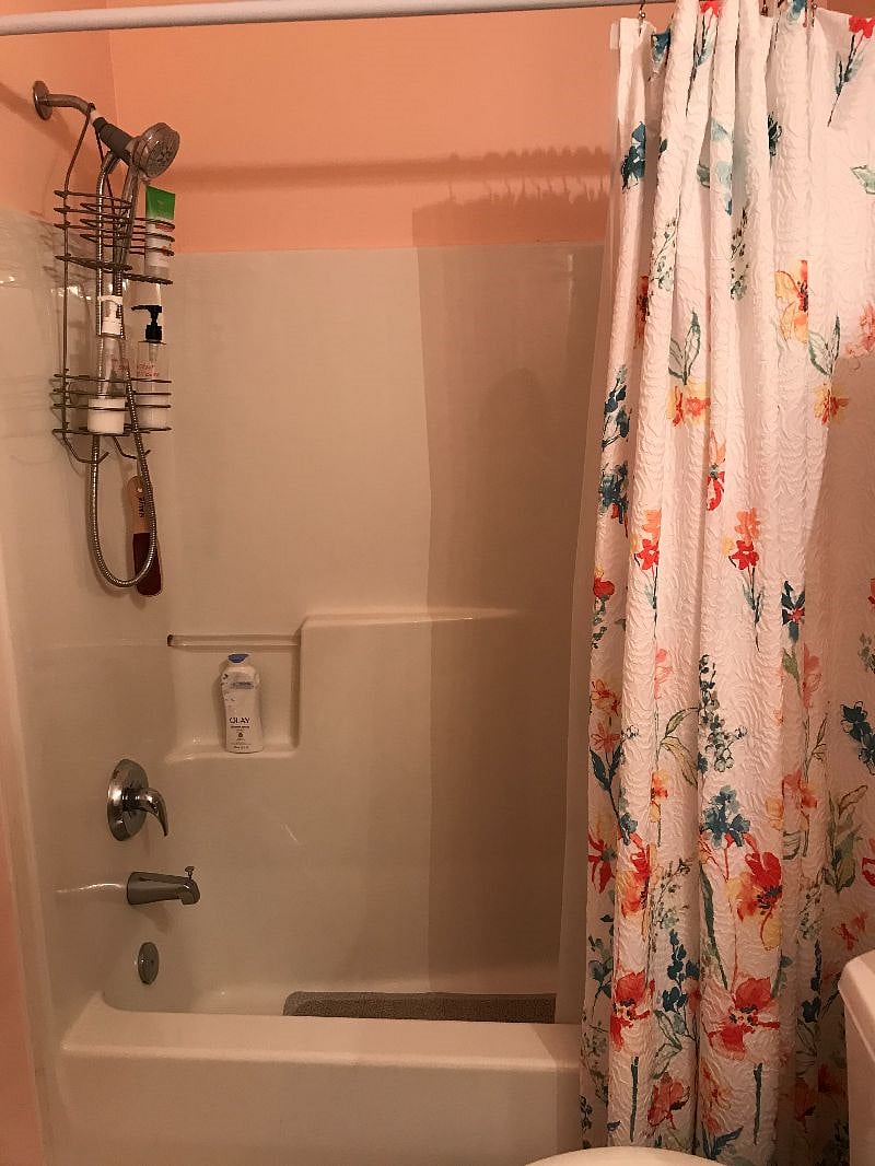 The Primary bathroom has a step in tub/shower with a showerhead and handheld sprayer