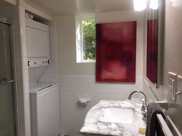 Bathroom window, washer/dryer, and a painting.