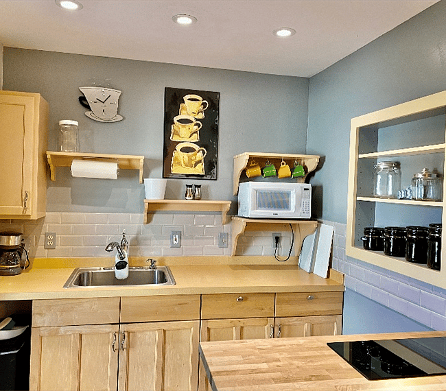 Kitchenette with broiler, microwave, coffee maker, smoothie maker, stove-top burners, fridge & storage space.