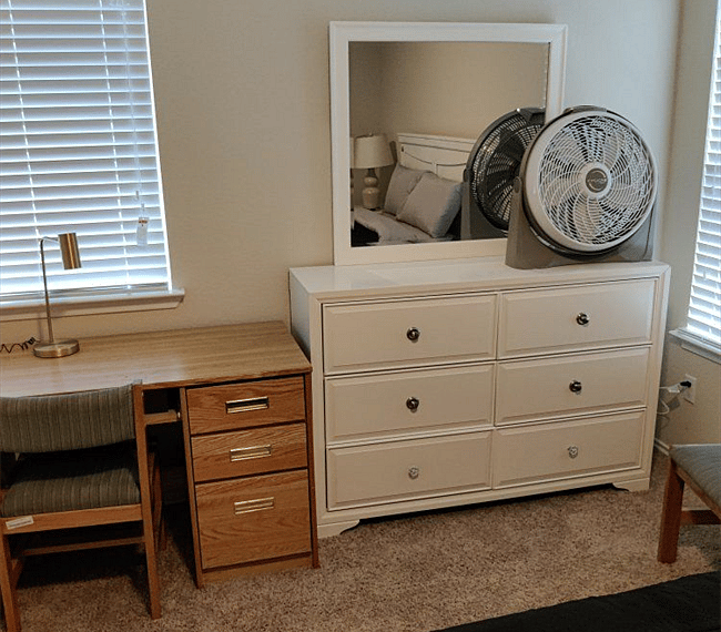 Desk and wardrobe with a mirror and a portable fan 