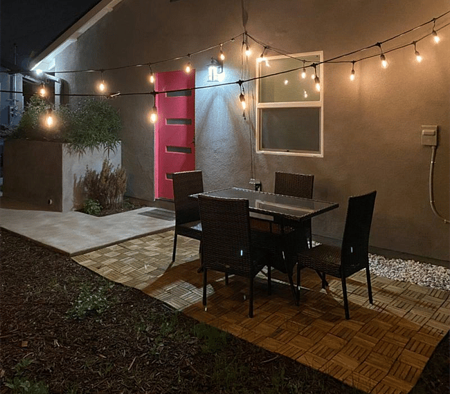 Outdoor patio with chillout area and string lighting.