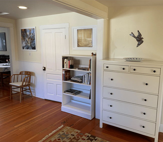 A linen cupboard, books and the door leading into the second bathroom.