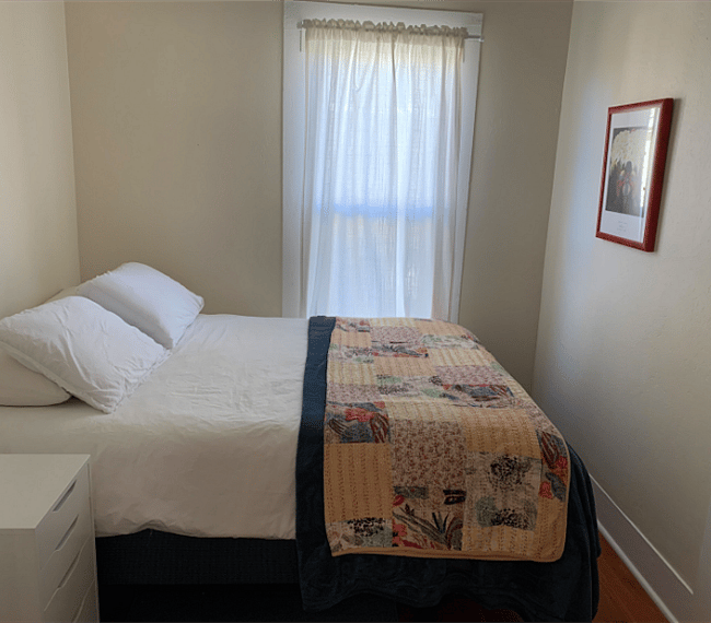 The second bedroom with a queen size bed, closet and a dresser.