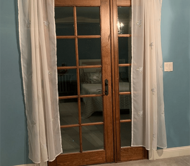 French doors from bedroom to balcony with seating