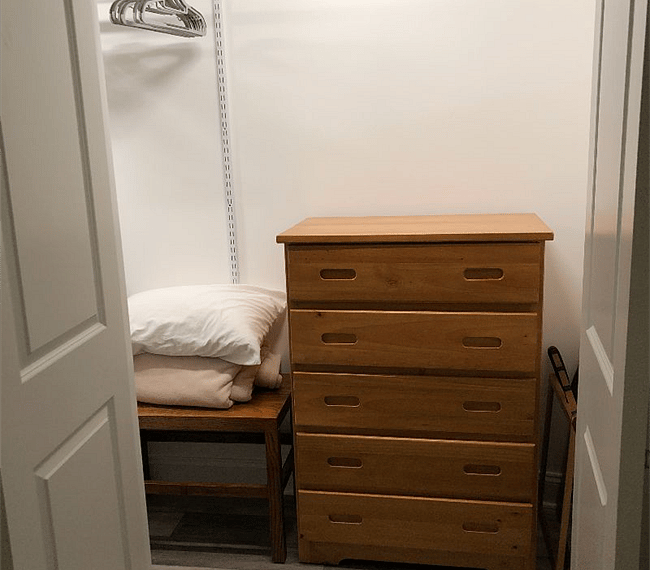 This is half of your two double door spacious closet in the bedroom. Includes a dresser and hamper for storing your clothes.