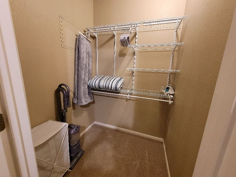 This walk-in closet is equipped with a closet organizer.