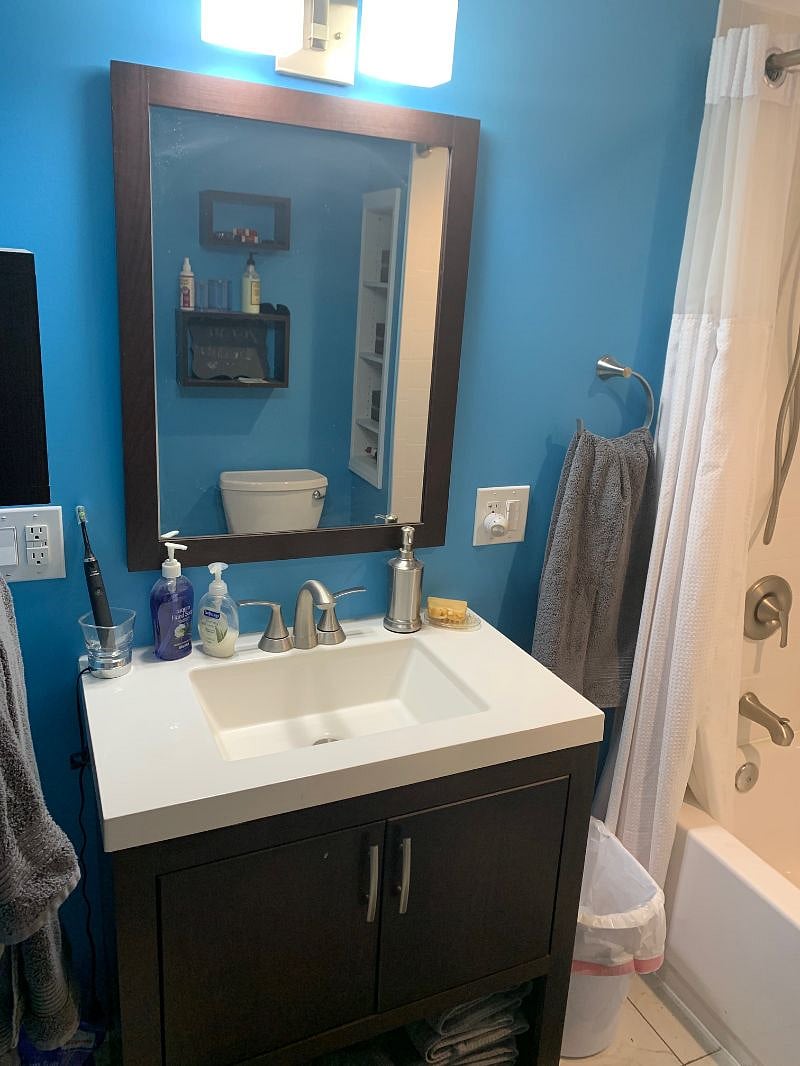Modern bathroom, sink with storage and towels, and great lighting.