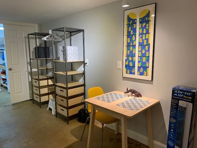 Kitchenette in attached room seen at left. Clothing storage with more bins, drawers and hanging rod. Table with chairs.
