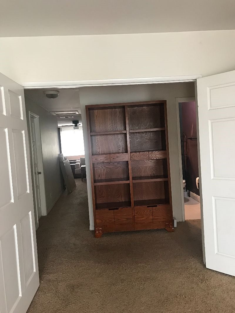 View inside apartment from Master bedroom through to front living room window - Bathroom on right