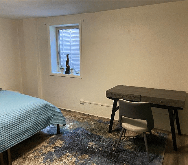 Another view of bedroom, fully compliant egress window and desk.