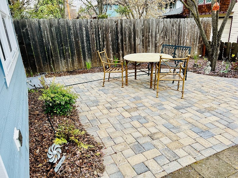front patio and table with chairs and a bench. cushions on porch and in shed in back.