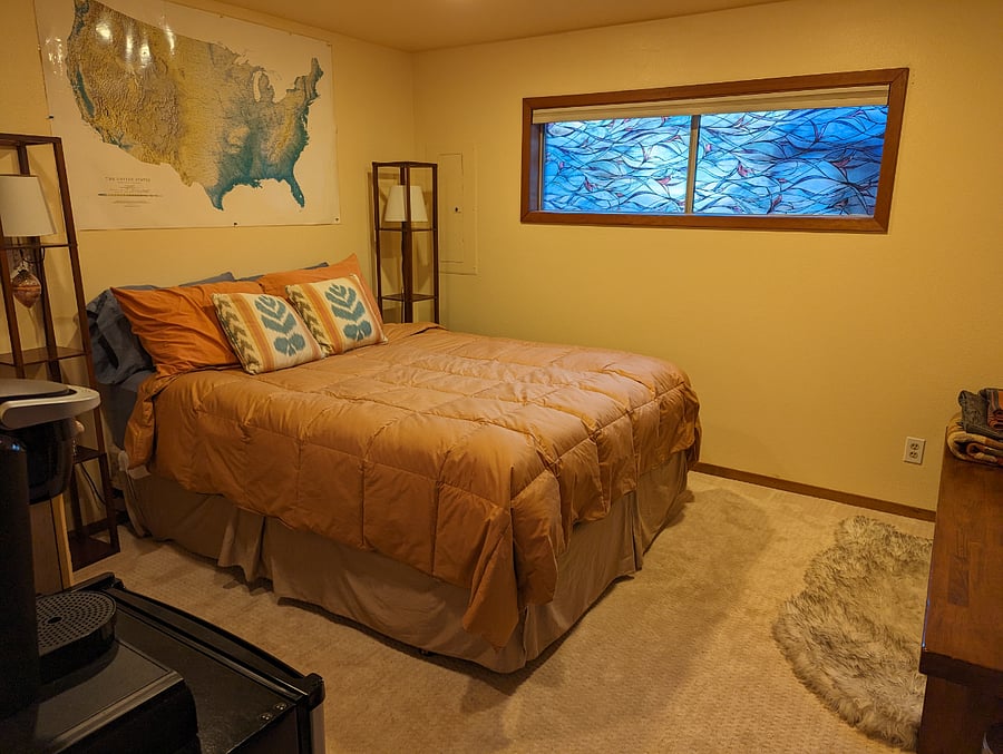 Quiet, dark becdroom with thick queen bed