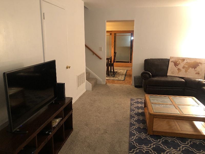 Living room that leads to the kitchen and upstairs