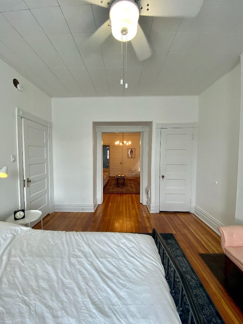 Front bedroom with blackout curtains and ceiling fan and closet. Sliding pocket doors connecting to the living room.