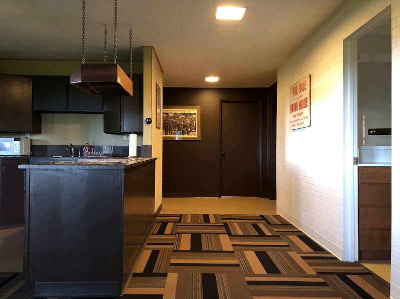 Kitchen on left, bath on right. Wide hallway leading to entrance (right side) and bedroom (left side). Straight ahead is locked door to upper unit.