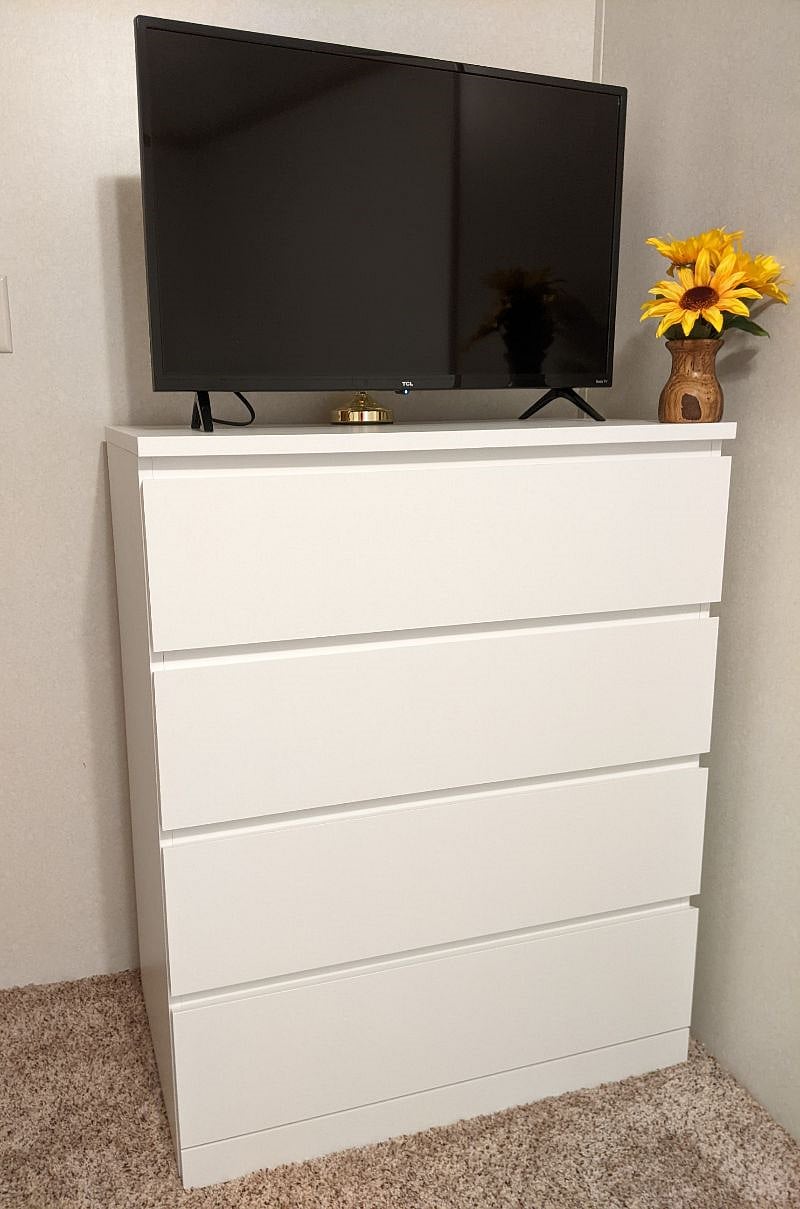 Chest of drawers and smart TV in twin bedroom