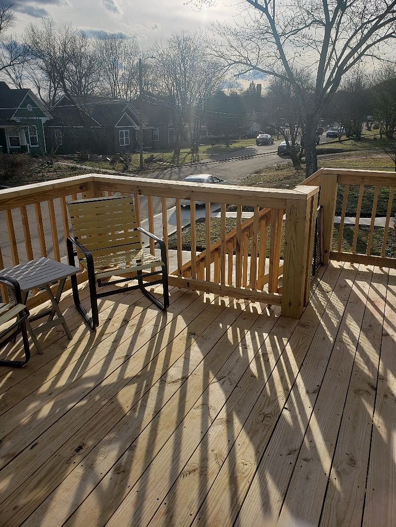 Raise large deck off sliding door from unit with grill/grill tools & sitting area. Stairs down to fenced yard and onto street.