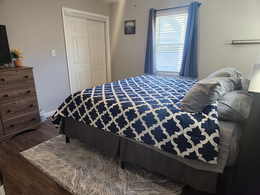 Bedroom 1 with king size bed, bookcase headboard, dresser and large closet.