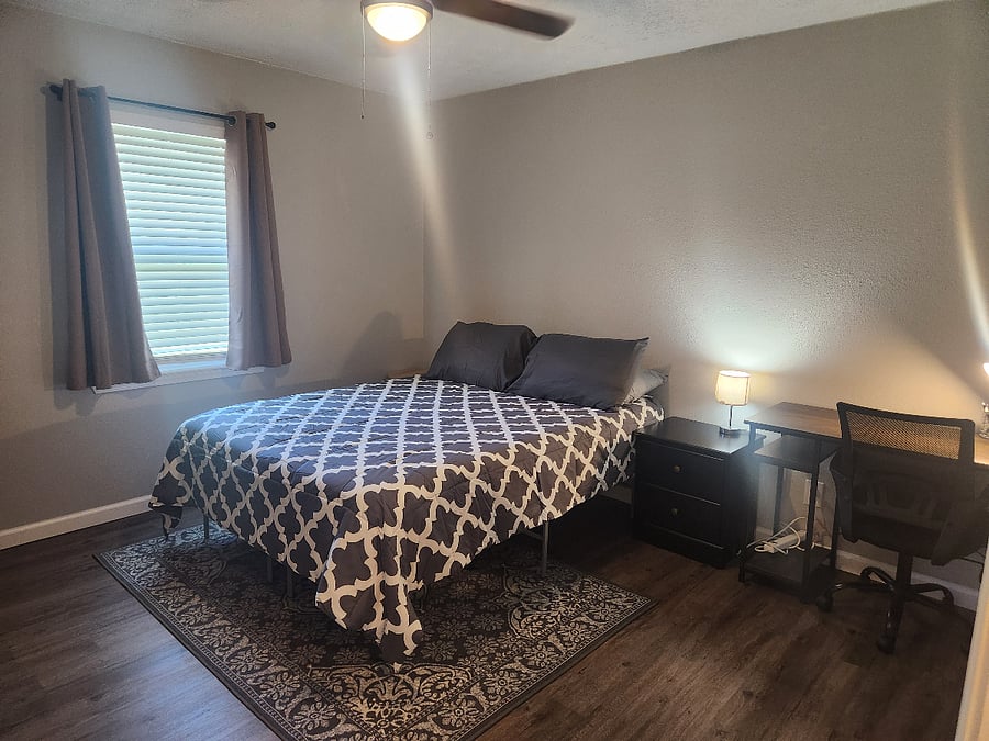 Bedroom2 with queen size bed and a dedicated work space w/ desk and chair. Has small dresser and a large closet.
