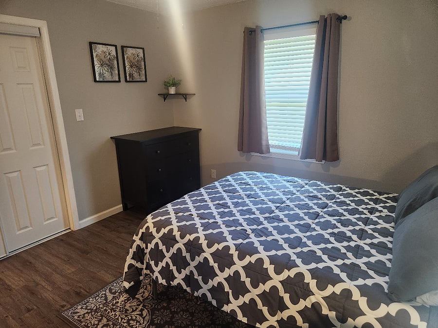 Bedroom2 with queen size bed and a dedicated work space w/ desk and chair. Has small dresser and a large closet.