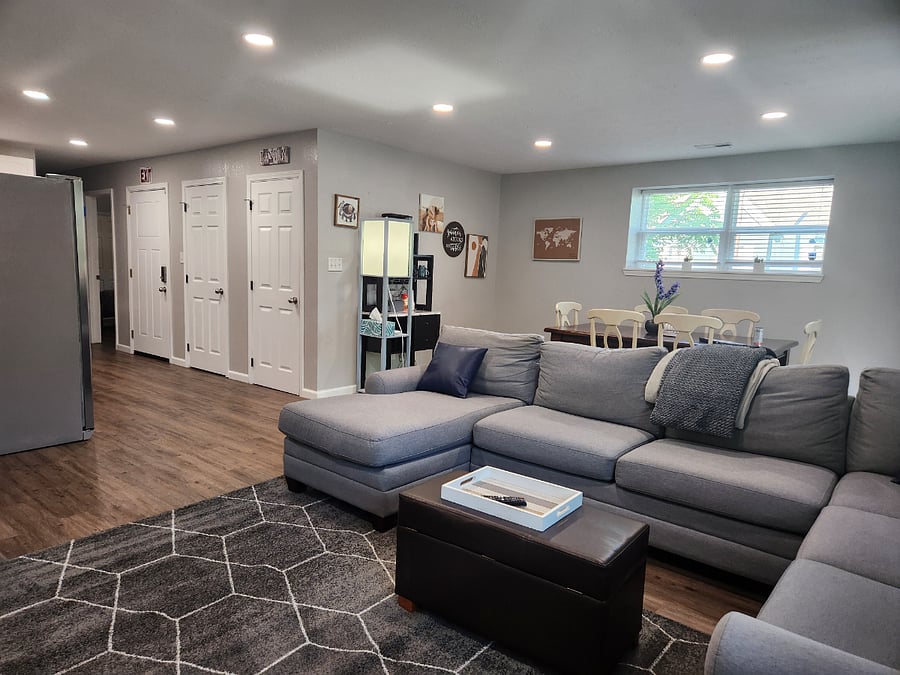 Huge, comfy sectional couch for evening movies or afternoon naps! Open floor plan to dining and kitchen. Bank of 3 doors shown are: 2nd point of egress into shared hallway, huge storage closet and pantry.