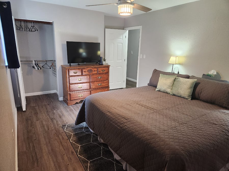 King bedroom with 43" smart tv, dresser and large closet. Bookcase headboard for ease of storing and charging. 20 hangers provided in each closet. Black out shade and curtains provided in all rooms.