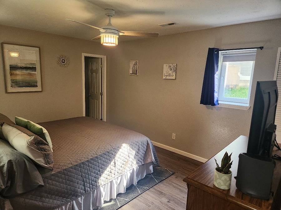 King bedroom with 43" smart tv, dresser and large closet. Door enters into bathroom. Bookcase headboard for ease of storing and charging. 20 hangers provided in each closet. Black out shade and curtains provided in all rooms.
