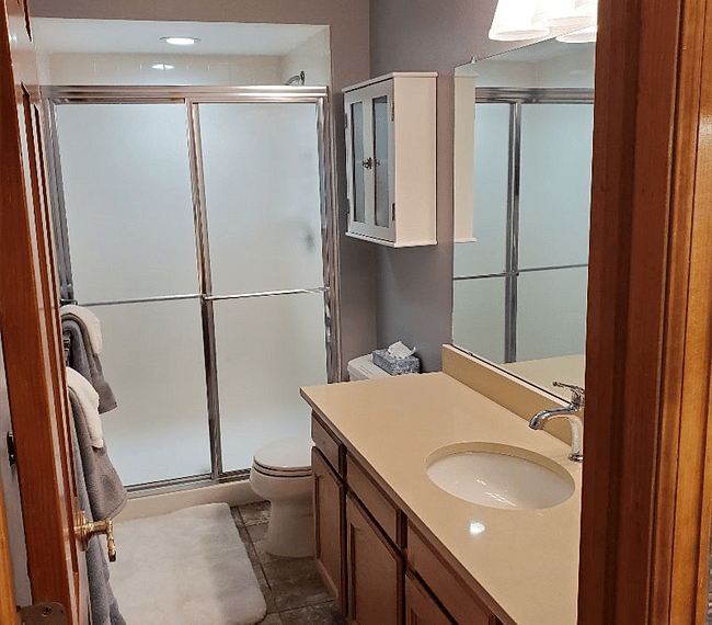 Bathroom with long counter top and heated tile floor.