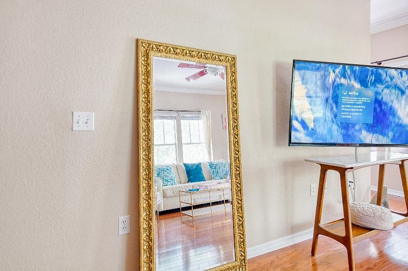 Large antique mirror in living room next to 60 inch apple TV with netflix, hulu, amazon prime and more.