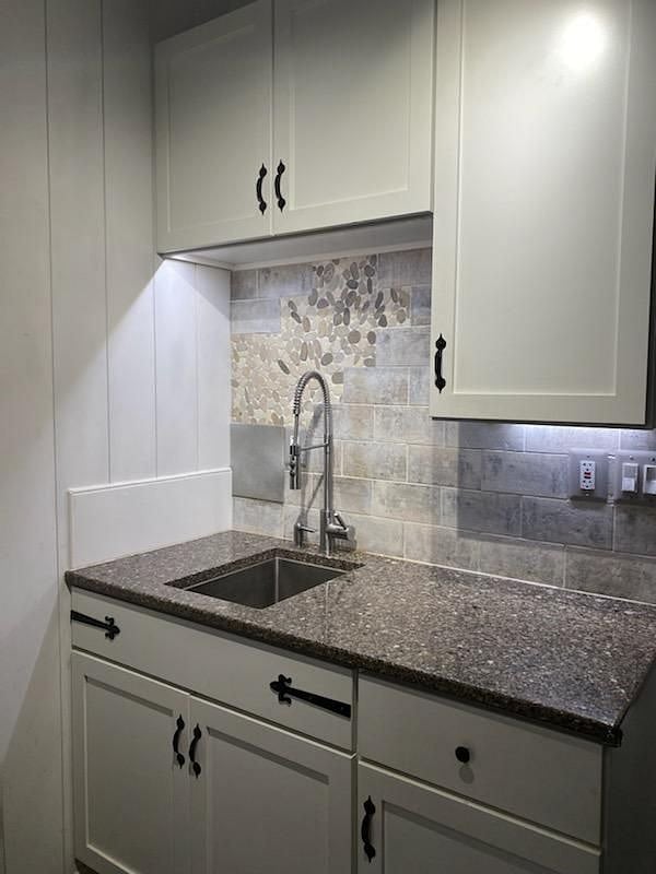Kitchen sink area showing underneath cabinet lighting