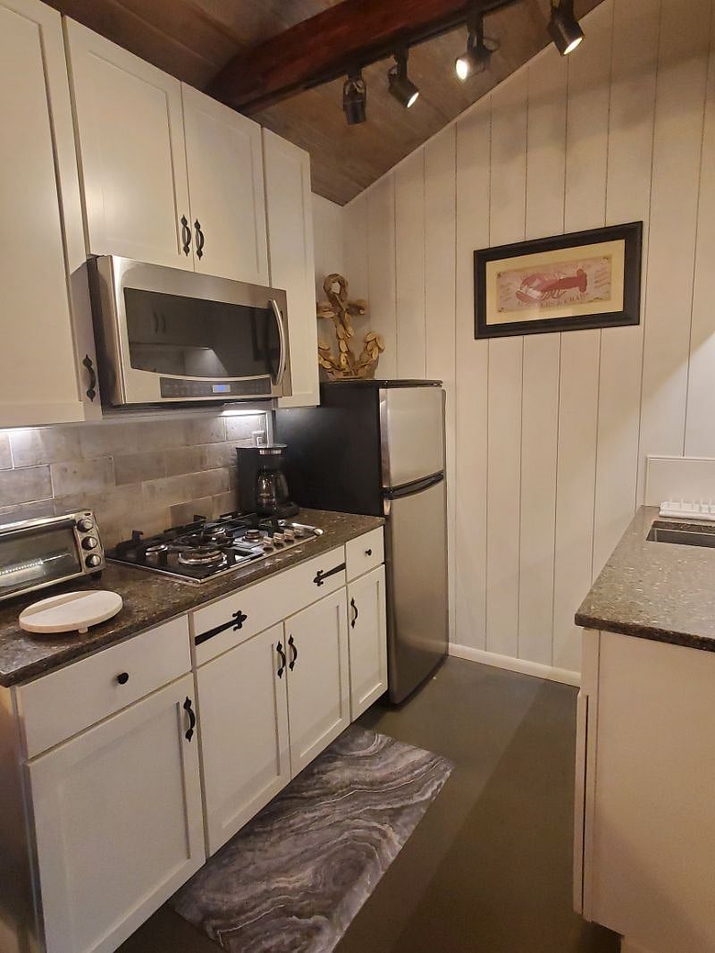 Kitchen showing coffee pot, refrigerator, convection microwave, and toaster oven.