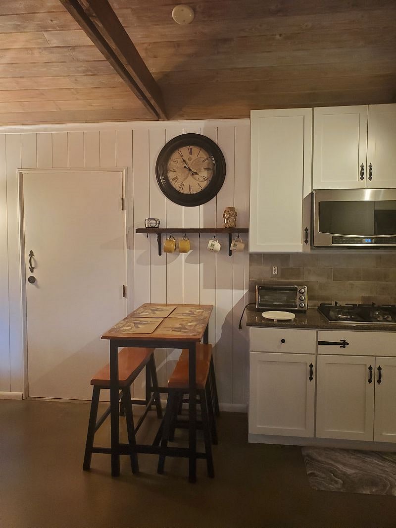 Dining table and Kitchen with toaster oven and convention microwave.