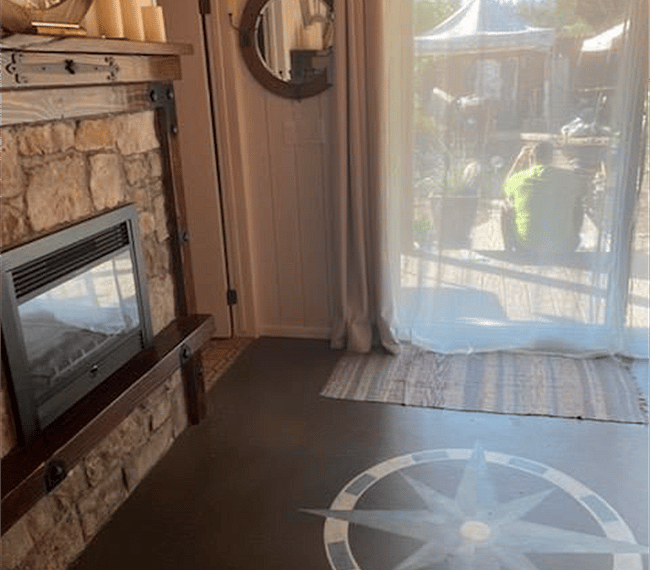 Main entrance locking sliding glass door. Curtains to let in light, as well as blackout curtains. Door to bathroom on left.