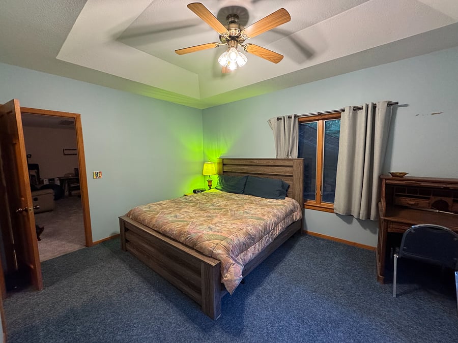 Bedroom with king size bed, and topper, black out curtains open in picture
