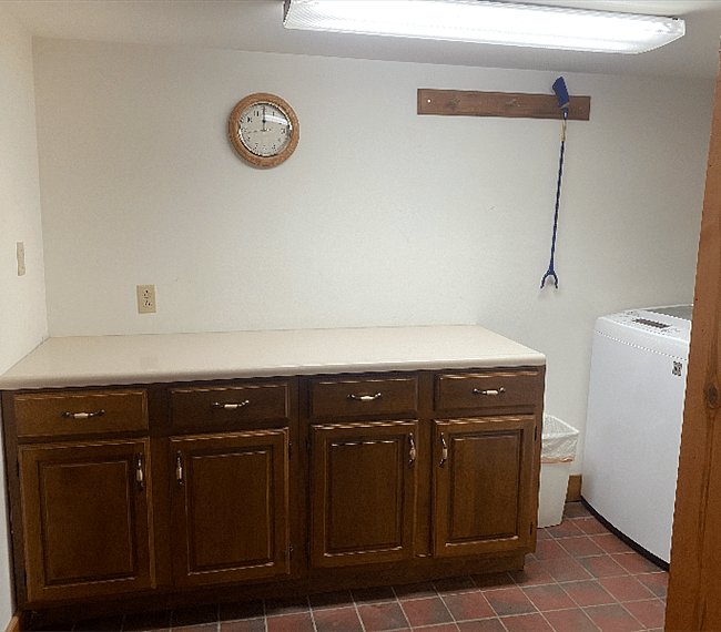 Laundry room, folding aea, also has a clothes line, ironing board and iron