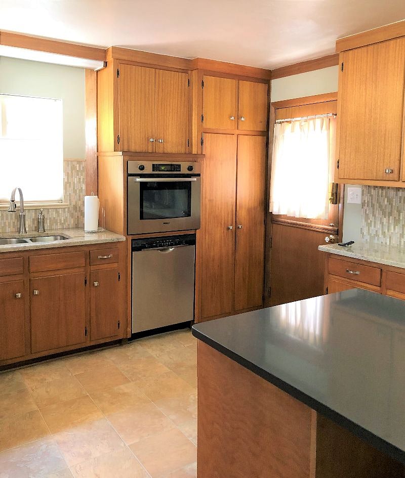 Bosch oven and dishwasher, granite counters, vintage Dutch door to the back deck