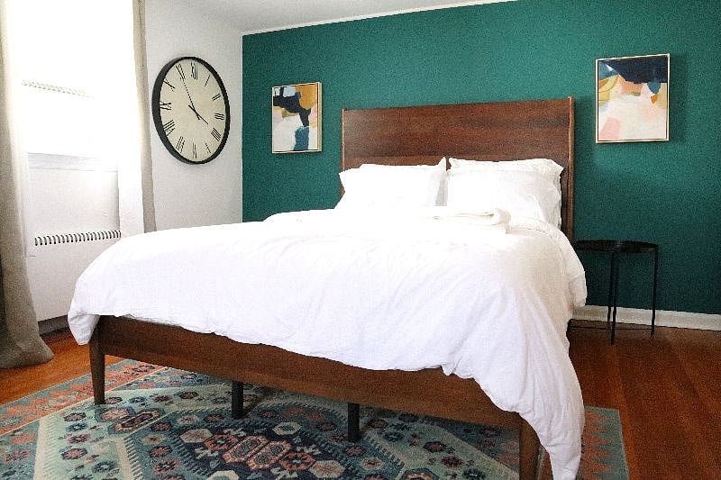 Bedroom with queen size bed, TV, night stands, charging station, air conditioning (summers only), and work area.