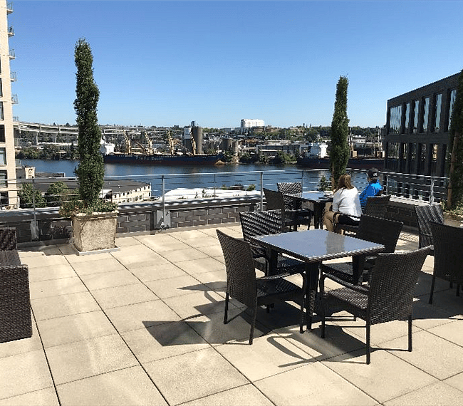 Two floors up is a cool terrace for the condominium residents. You'll enjoy views of ships on the river, Portland's NE side, and mountains beyond. Find your spot amongst the assortment of chairs, tables and couches. (Don't forget your sunscreen!)