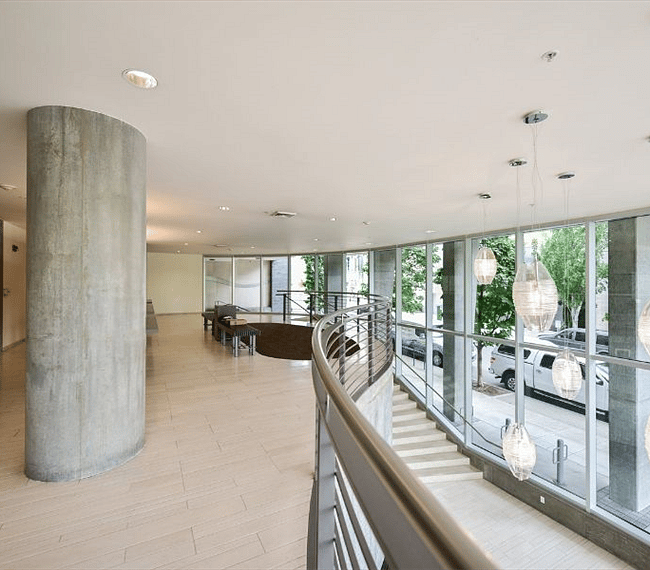 The lobby balcony overlooks the main entry below where a full wall of glass keeps it light and bright.