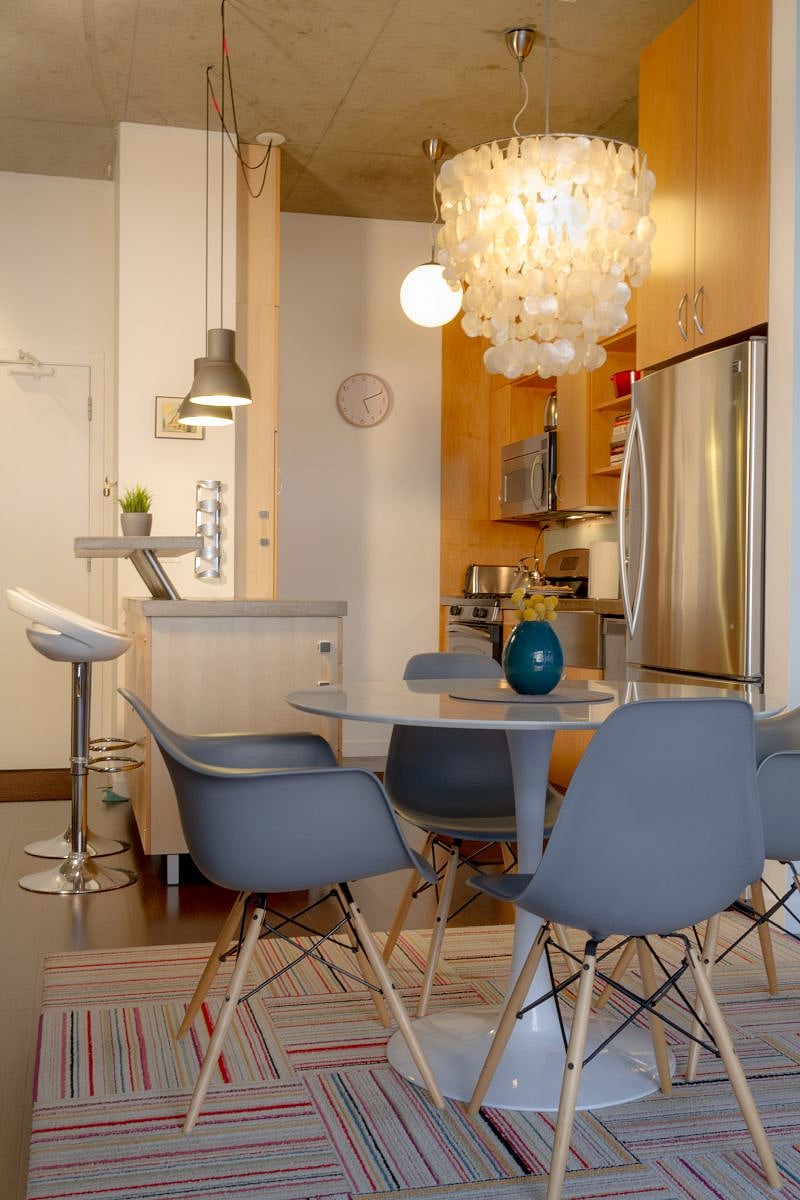 The kitchen features bar-top seating for two, stainless steel appliances, large farmhouse-style sink, glass backsplash, concrete counter tops, plenty of work surface and so much storage.