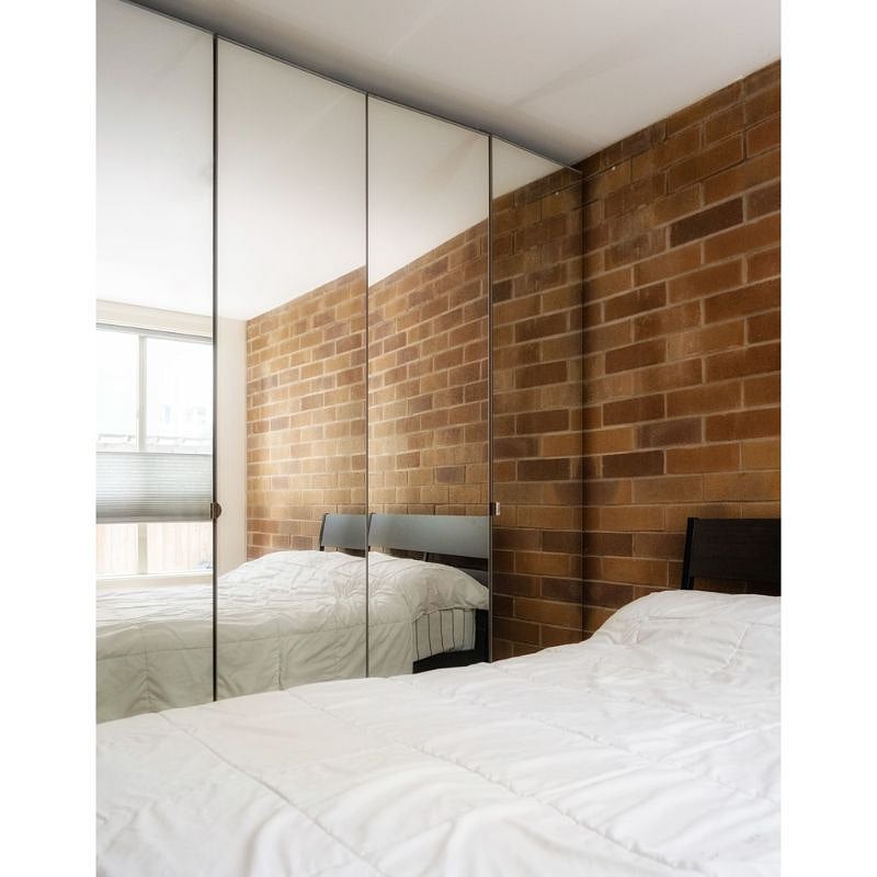 Bedroom with floor-to-ceiling, mirrored wardrobe storage system