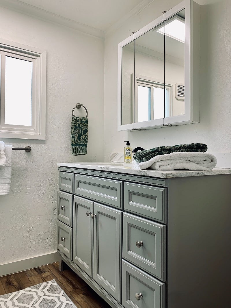 Bright bathroom with storage in the vanity and mirror.
